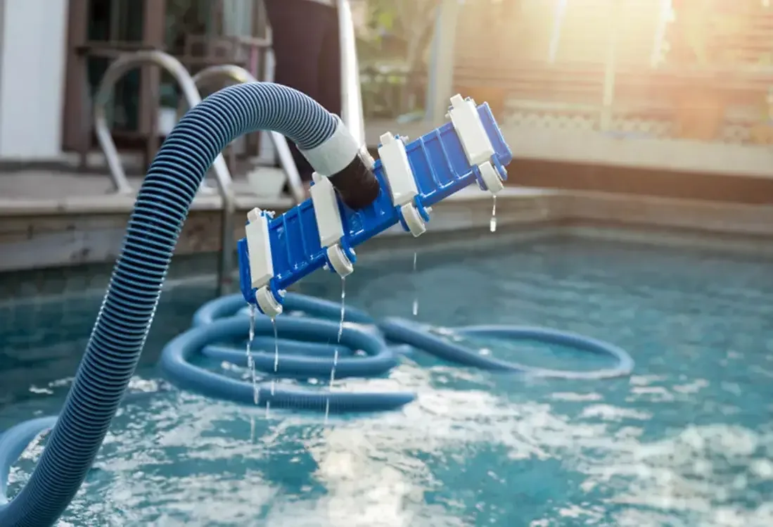 Pool equipment and hose beside blue water
