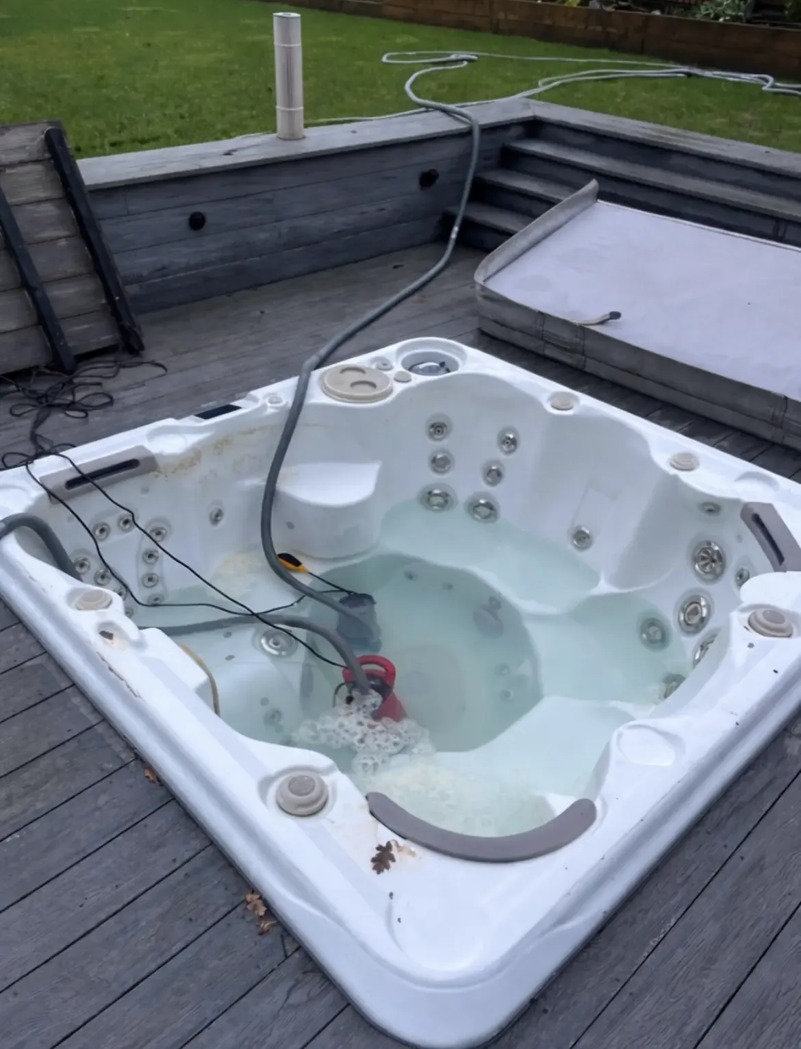 Hot tub being drained with a pump hose